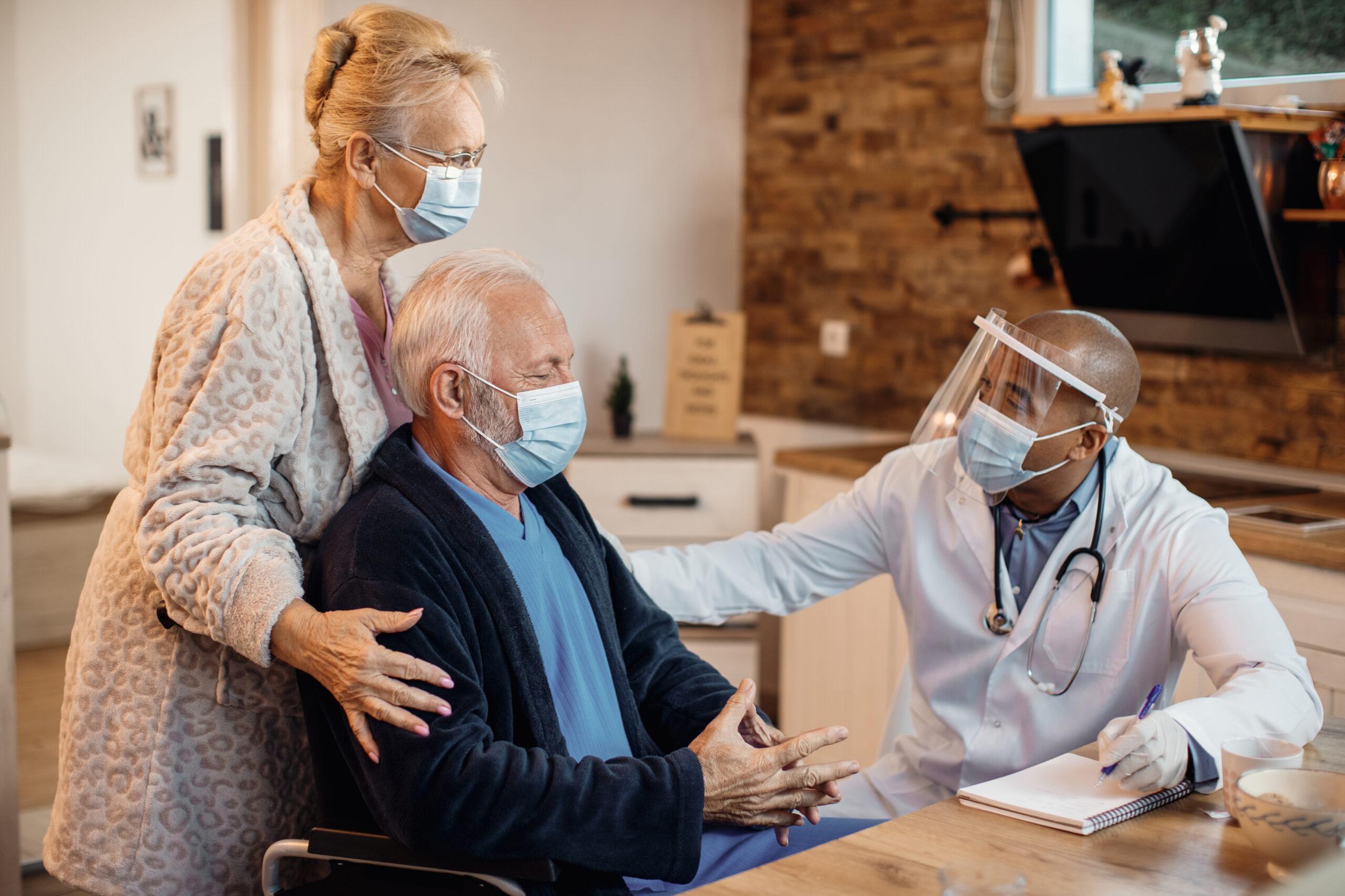 Senior couple with Covid meeting with doctor