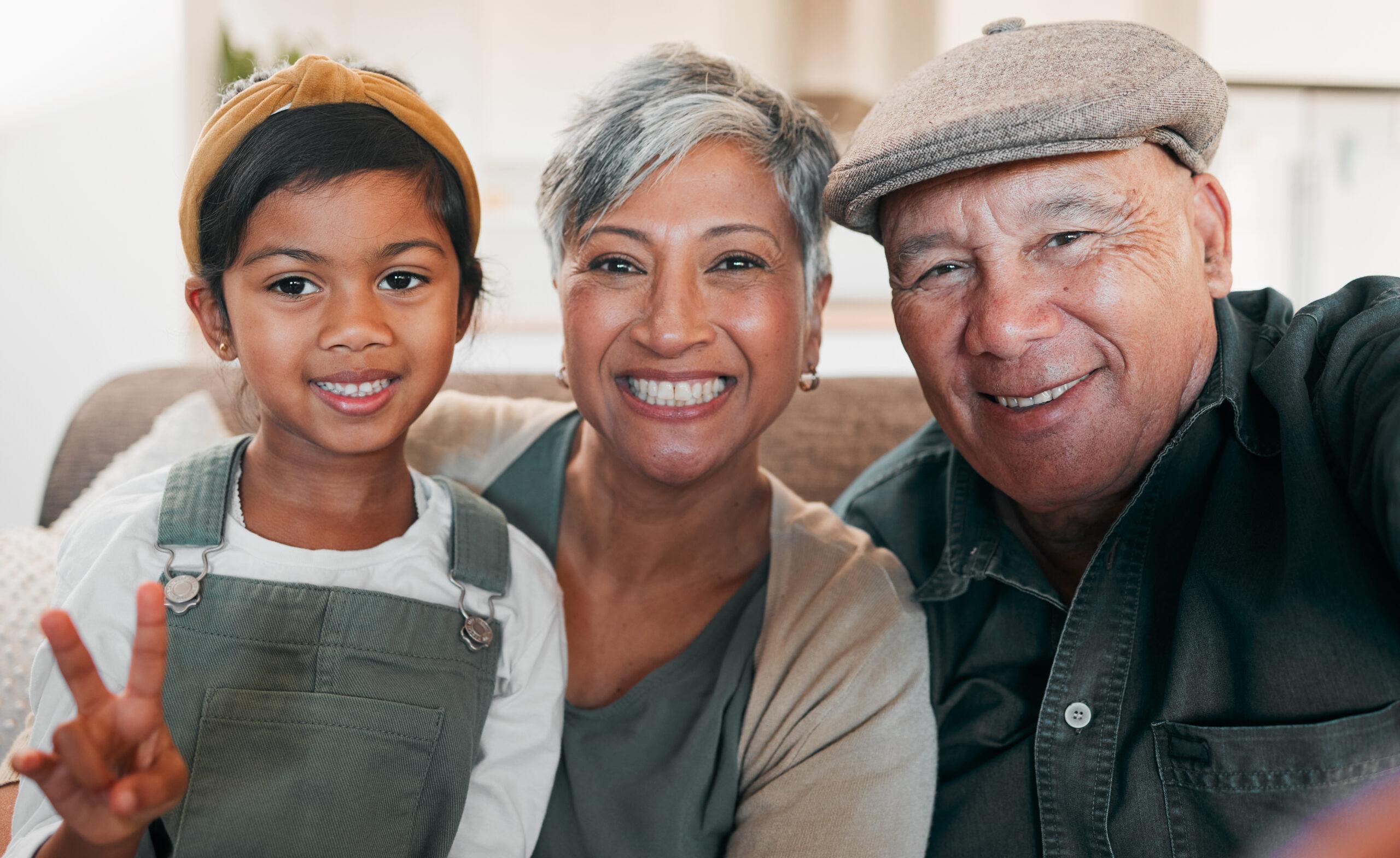 Grandparents sitting on couch with grandchild