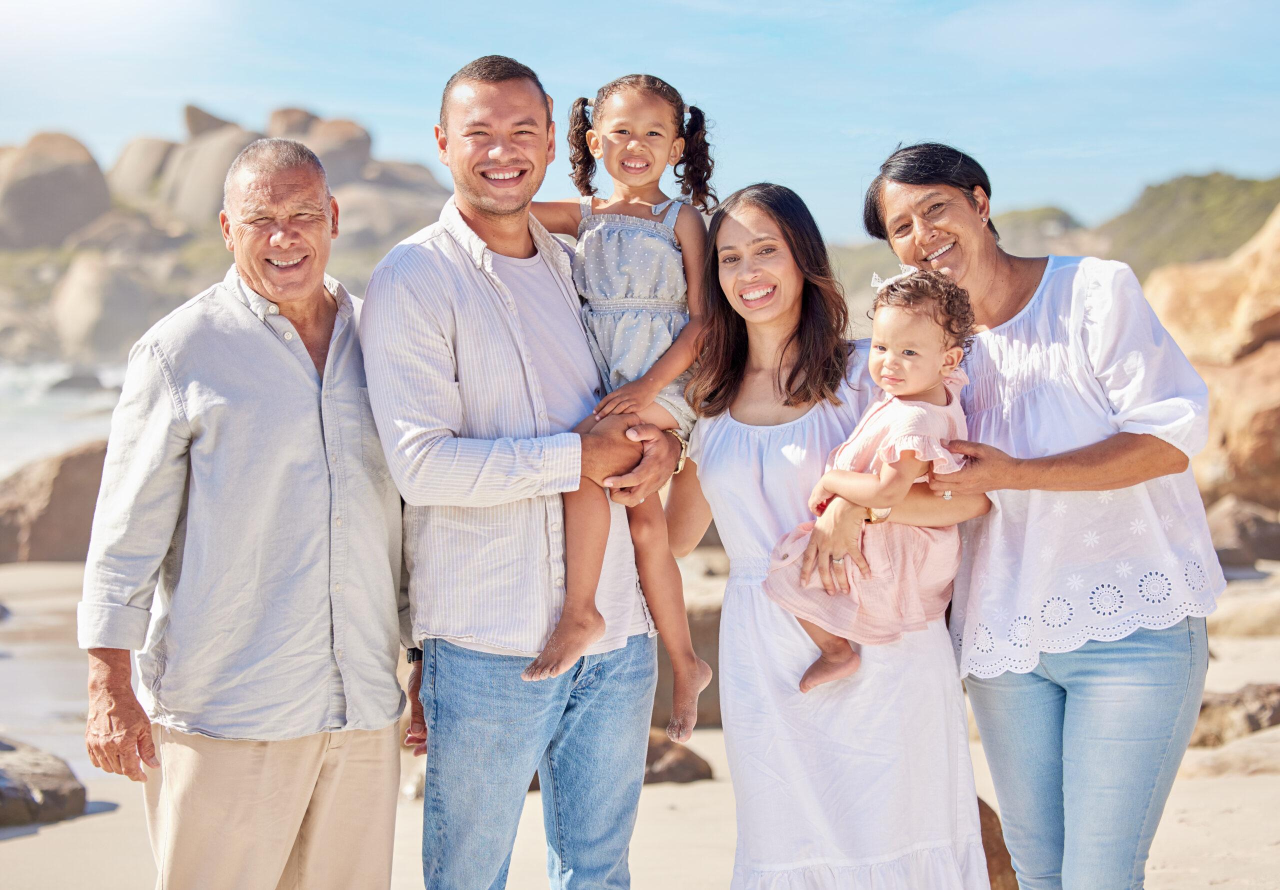 Portrait of smiling family standing together on beach.