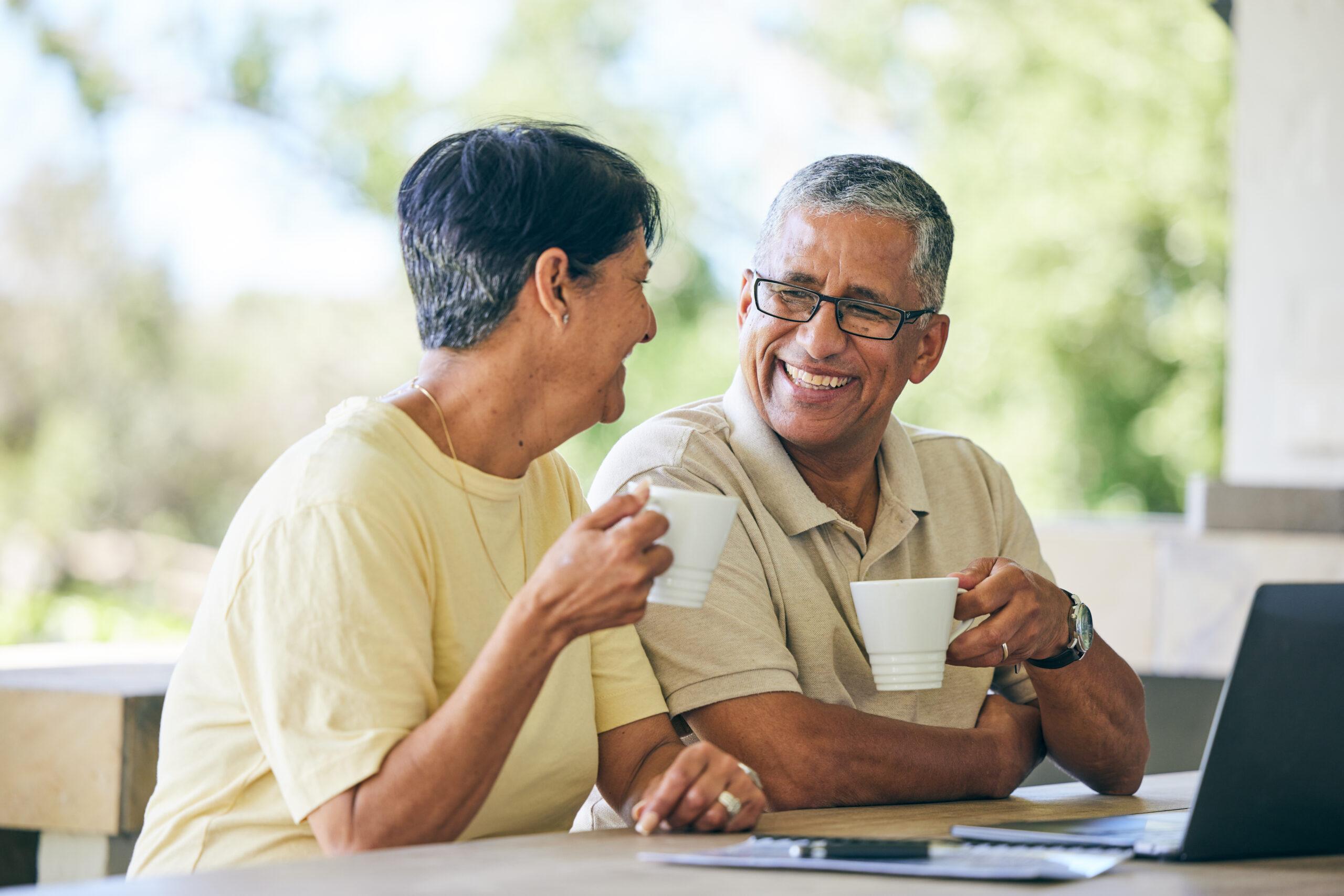 Couple having coffee and looking at laptop