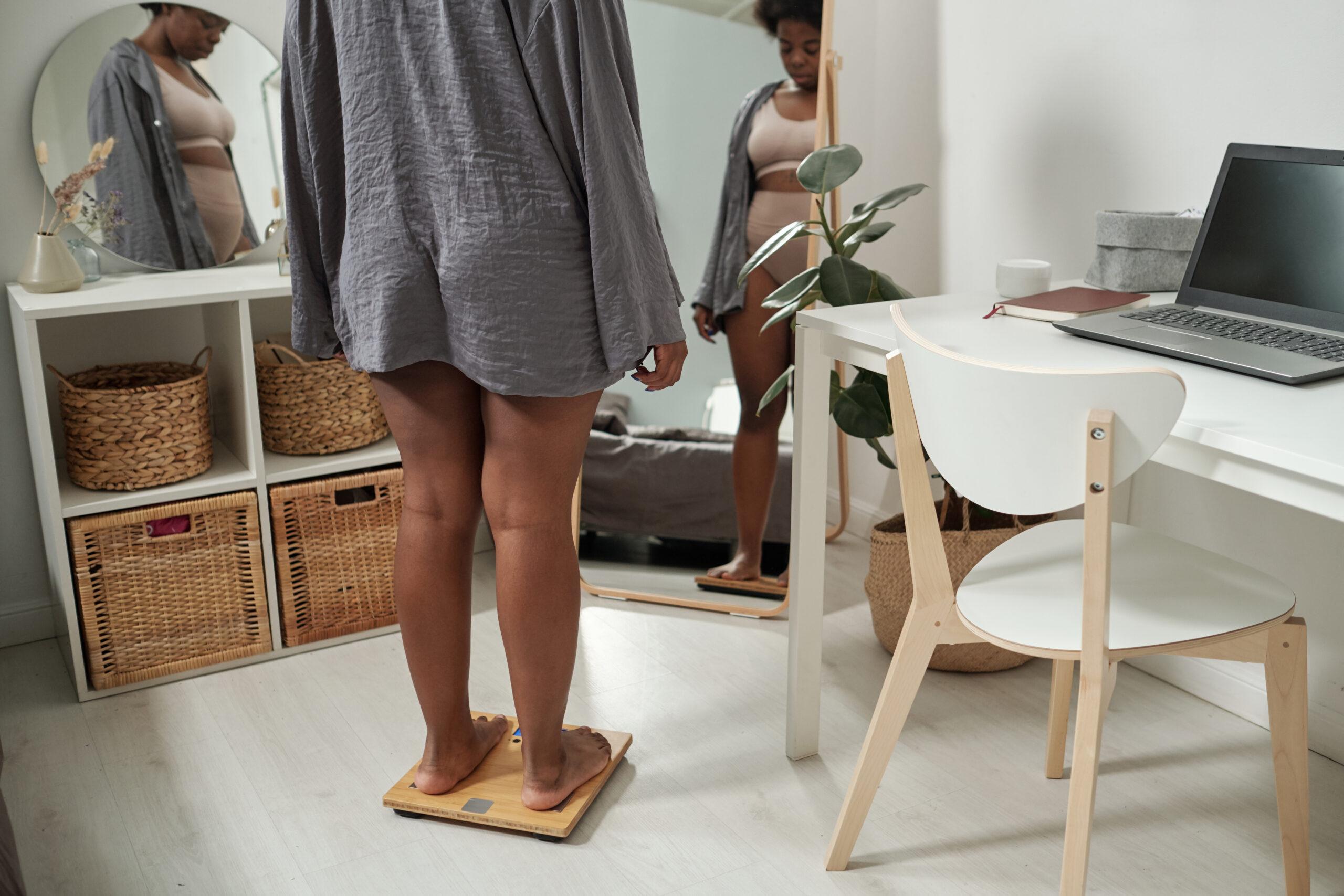 Woman standing on scale in front of mirror