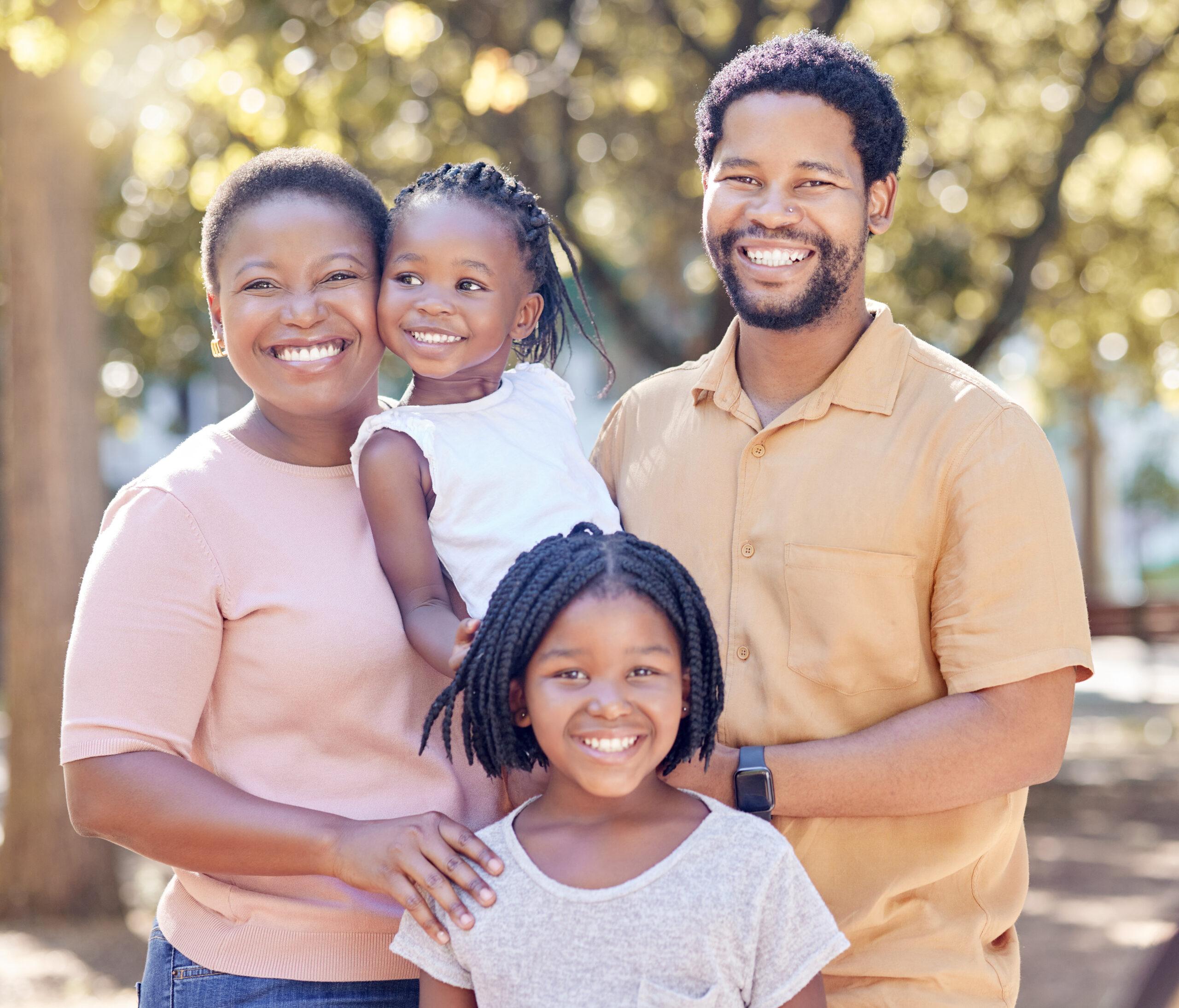 Portrait of a happy family in a garden for a summer picnic while on holiday.