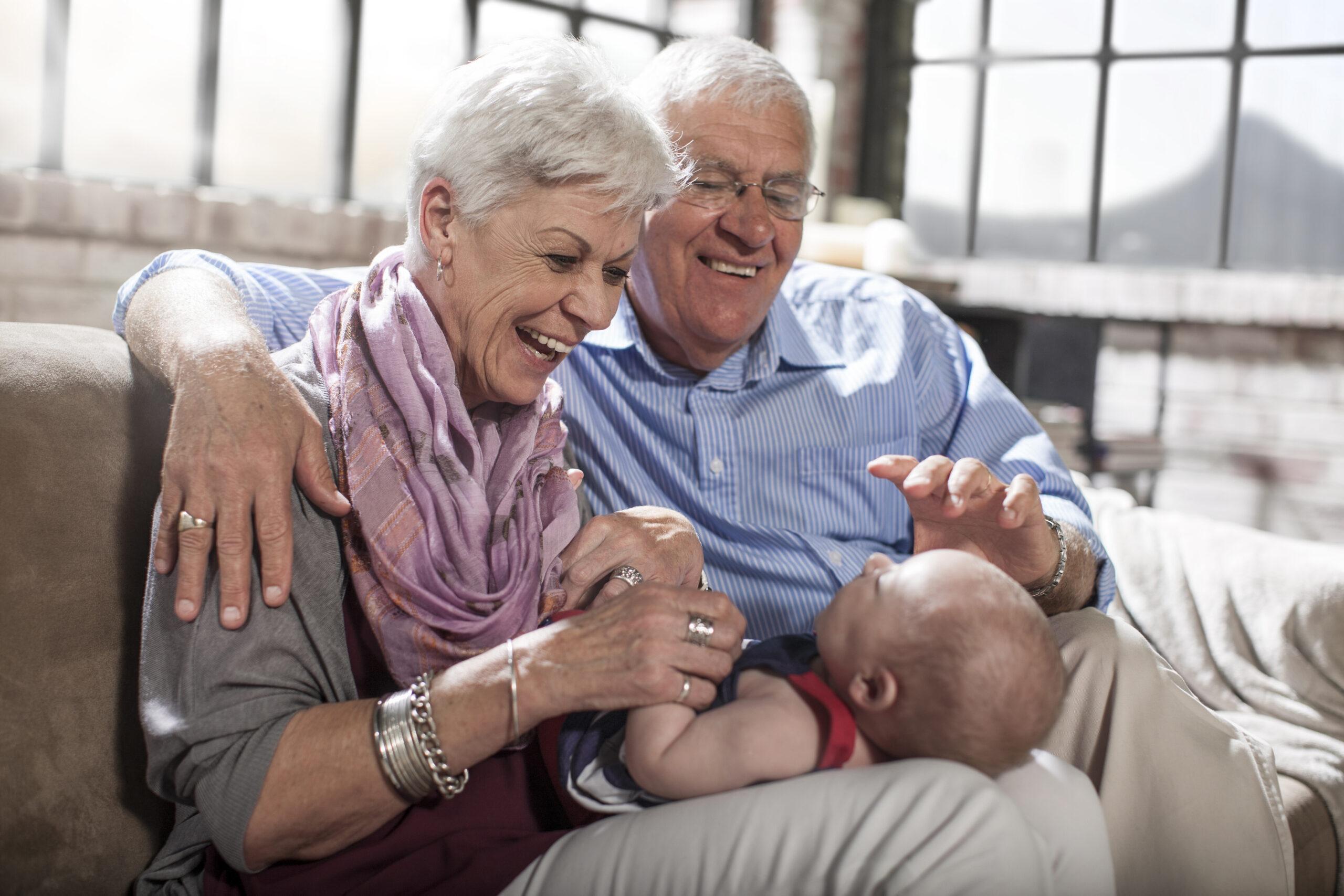 Grandparents playing with granddaughter at home