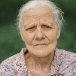 Portrait Sad old woman. Portrait of a gray-haired adult grandmother against the background of nature