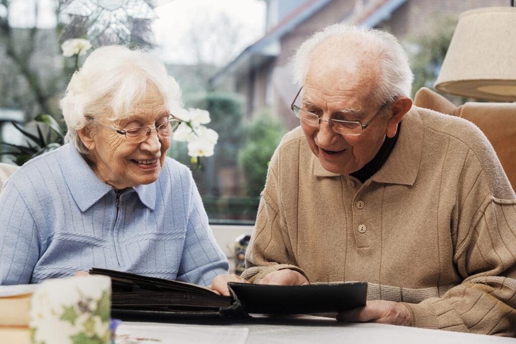 An elderly couple looking at photographs together.