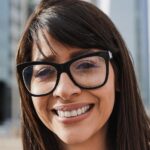 Young latin business woman working outside of office with city in background