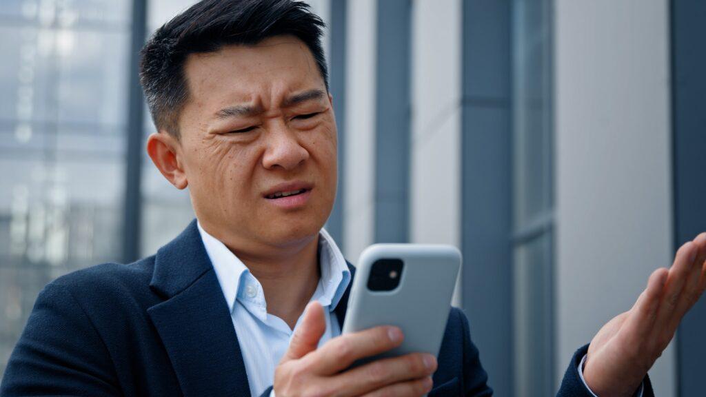 Close up Asian middle-aged adult man mad unhappy businessman feeling annoyed with using broken smart