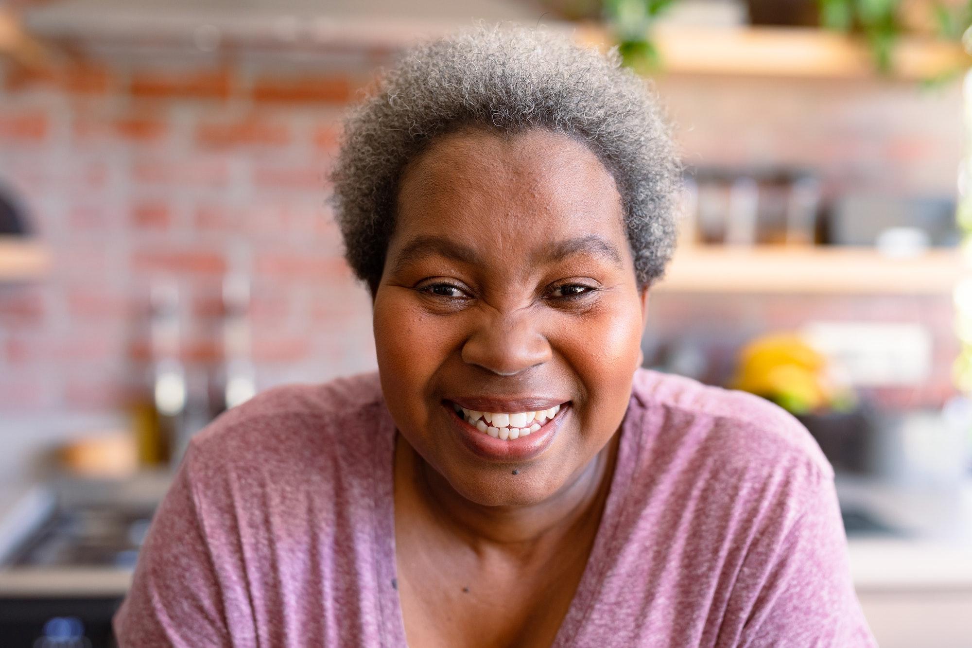 Portrait of happy african american senior woman it kitchen