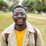 Smiling african young student man looking at camera outdoors