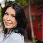 Smiling confident middle-aged caucasian woman with dark brown hair looking at the camera