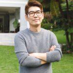 Portrait of happy asian man wearing glasses smiling in garden outside family home