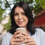 Cropped close up portrait of a pretty caucasian middle-aged mature woman drinking