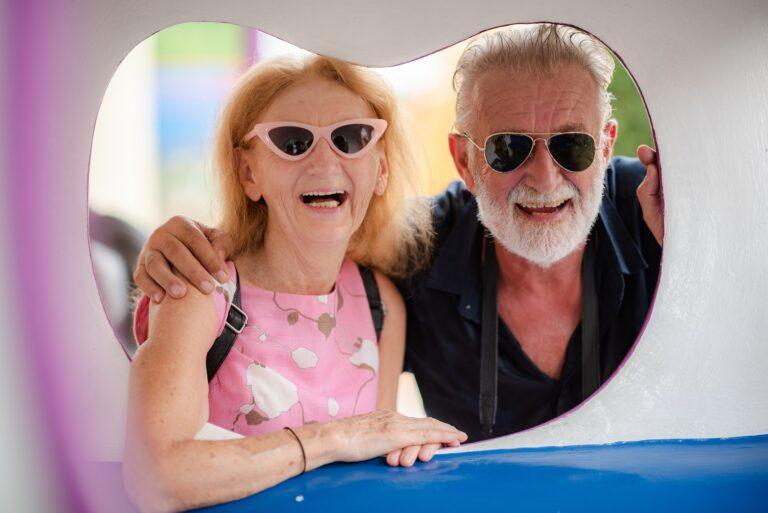elderly senior couple woman and man having fun and happy together at amusement them park