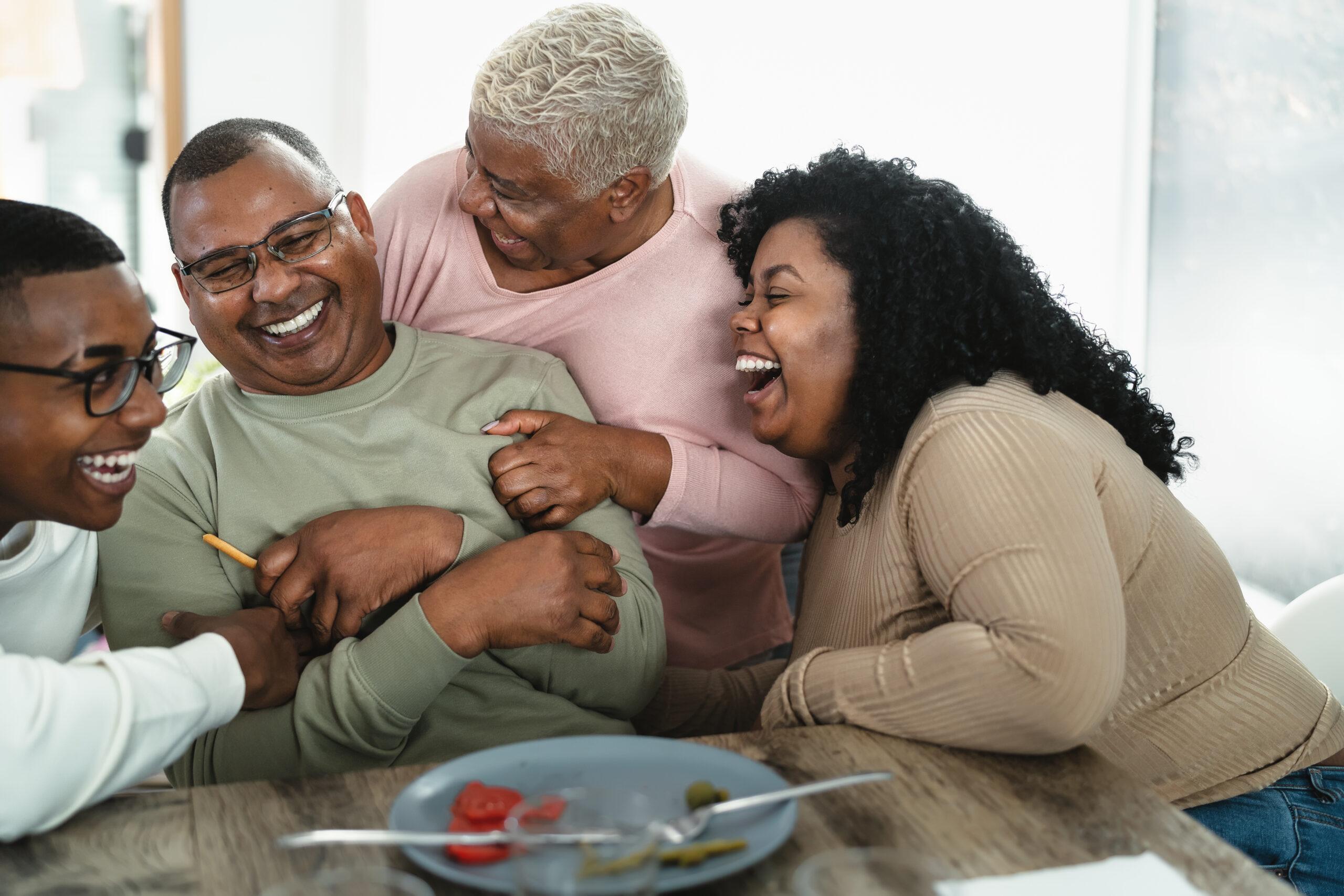 Happy black family having fun after a lunch together at home