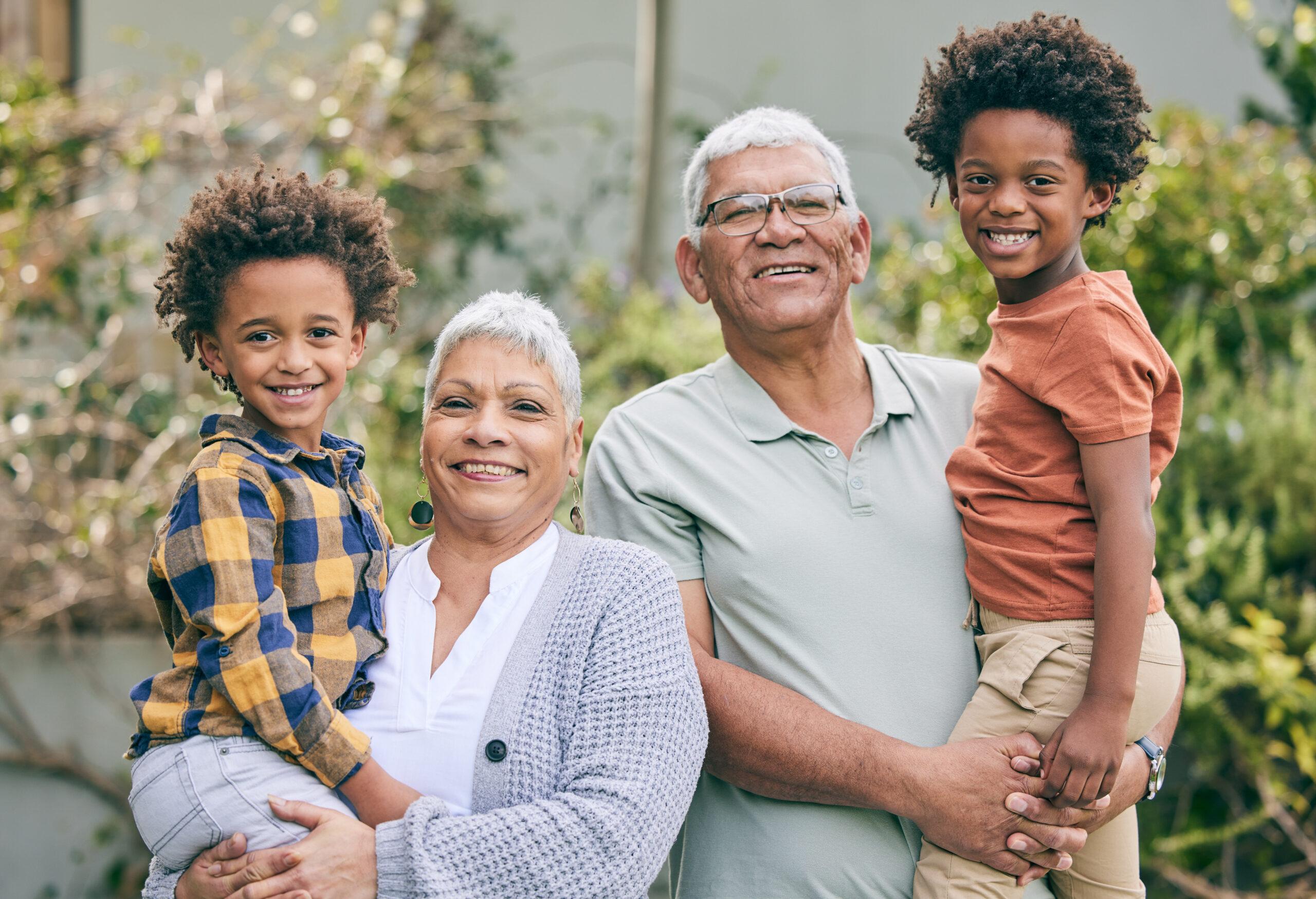 An older couple with their grandchildren, smiling.