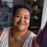 A senior woman smiling and looking off into the distance.