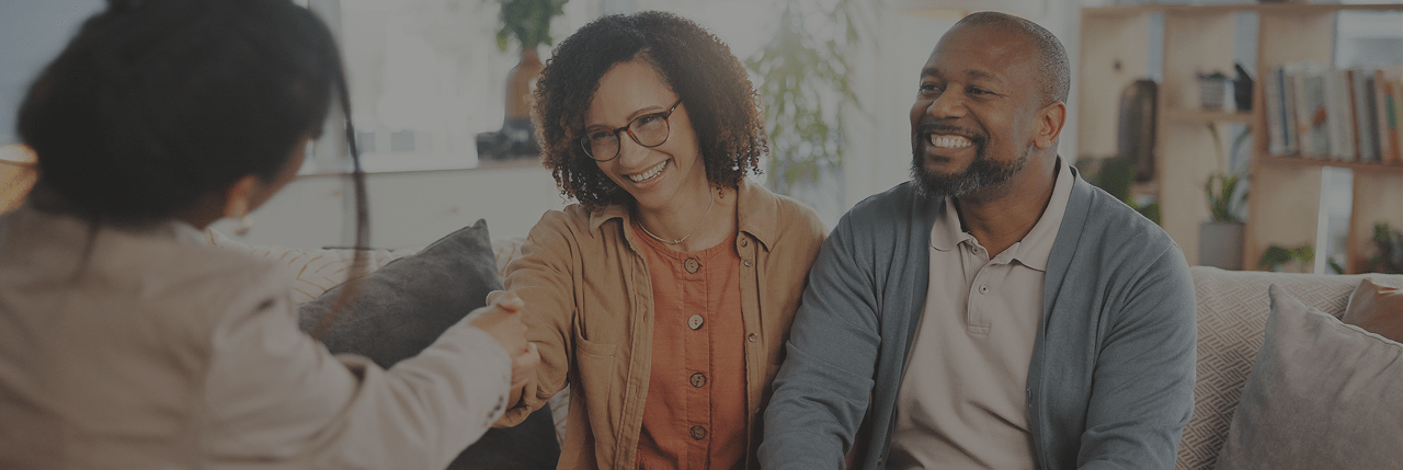 Couple shaking hands with finacial advisor