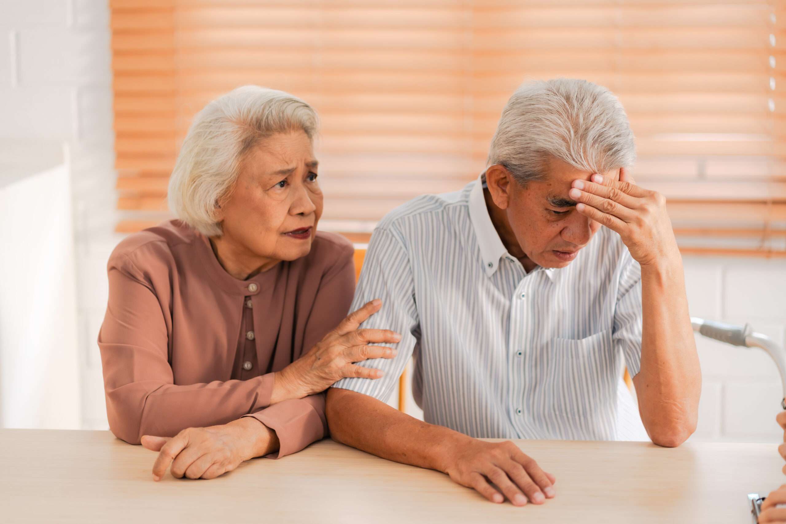 Elderly couple looking stressed at the kitchen, life insurance and divorce
