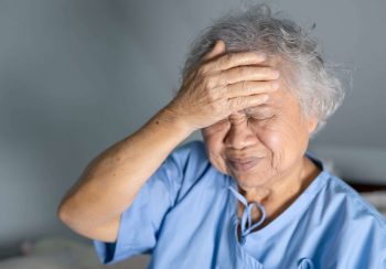 Asian senior or elderly old lady woman patient headache while sitting on bed in nursing hospital ward, healthy strong medical concept