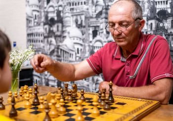 brunette-boy-playing-a-game-of-chess-on-large-ches-2024-12-04-01-30-57-utc