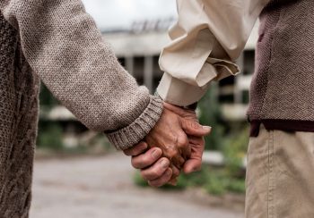 cropped view of retired man and woman holding hands