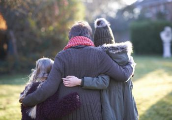 Grandmother and granddaughters hugging in garden