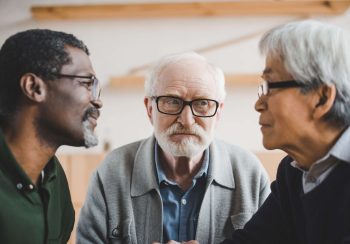 group of focused multiethnic senior friends playing staring contest