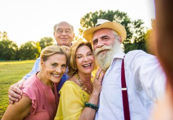 Group of youthful seniors having fun outdoors - Four pensioners bonding outdoors, concepts about lifestyle and elderly