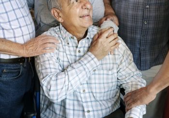 Elderly men cheer up his friend on a wheelchair
