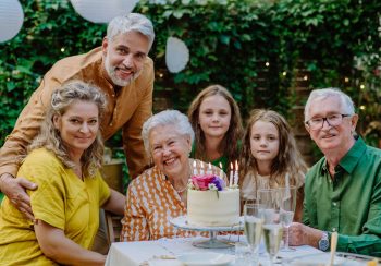 A multi-generation family on outdoor summer garden party, celebrating birthday