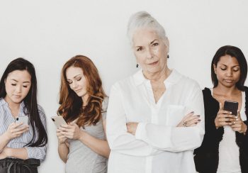 Senior woman standing in front of social media addicted people