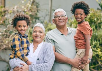 An older couple with their grandchildren, smiling.