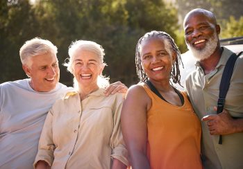 Portrait Of Group Of Senior Friends Going For Hike In Countryside Standing By Car Together