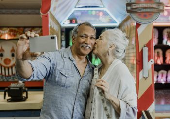 Happy senior couple taking a selfie with raffle tickets
