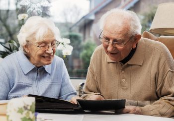 An elderly couple looking at photographs together.