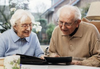 Senior couple watching old photographs at home